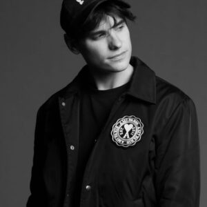 DJ Audien wearing black, black and white photo, black hat and jacket.